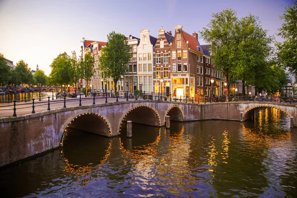 Amsterdam ışık, kanal ve köprü ile akşam görüldü