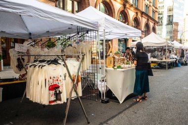 NEW YORK CITY - AUGUST 24, 2019:  View of tent street fair at Astor Place in Manhattan with people visible. clipart