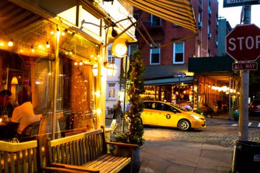 New York City - 24 Ağustos 2019: Greenwich Village, West Village Manhattan'dan gece görülen restoran, ışıklar ve geceleri insanların yer aldığı sokak sahnesi.
