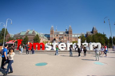 Amsterdam, Hollanda - 2 Eylül 2018: Arka planda tarihi Rijksmuseum ile I Amsterdam tabelasında ziyaretçilerin görünümü