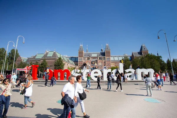 Amsterdam, Hollanda - 2 Eylül 2018: Arka planda tarihi Rijksmuseum ile I Amsterdam tabelasında ziyaretçilerin görünümü