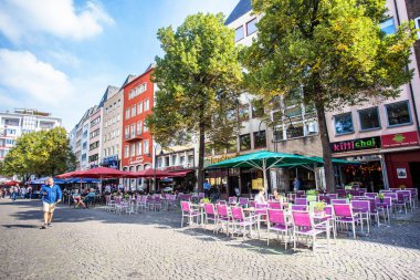 Köln, Almanya - 4 Eylül 2018: Köln Almanya 'dan insanlar, restoranlar ve kaldırım taşlı caddelerle dolu renkli sokak manzarası.
