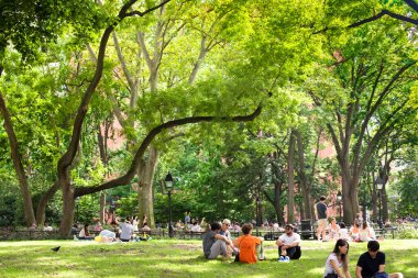 New York City - 15 Ağustos 2020: İnsanlar Manhattan 'daki Washington Square Park' ta bir yaz öğleden sonra sahnesinde dinleniyor. 