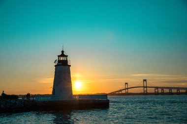 Newport Limanı Deniz feneri üzerinde gün batımı Köprü ve renkli gökyüzü