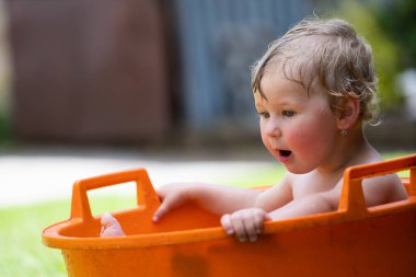 Bebeğim turuncu havuzda oynuyor.