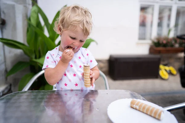 Bambina mangiando tubo con panna montata — Foto Stock