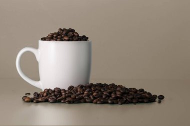 Kahve çekirdeği dolu boş beyaz bir fincan. Beyaz model.