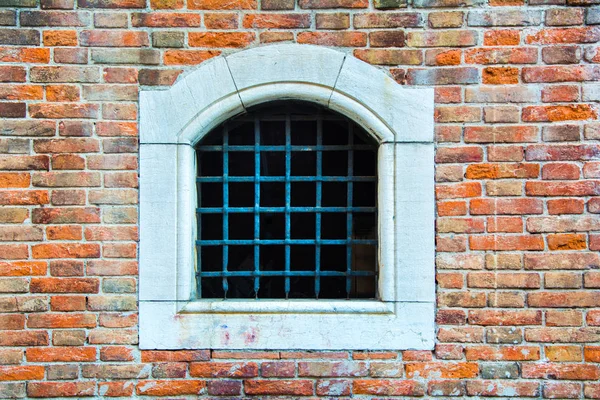Uma janela antiga fechada por uma treliça — Fotografia de Stock