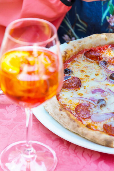 A glass with bright orange liquid, ice and a slice of orange, Sp