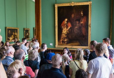 Visitors admire paintings by Rembrandt, 
