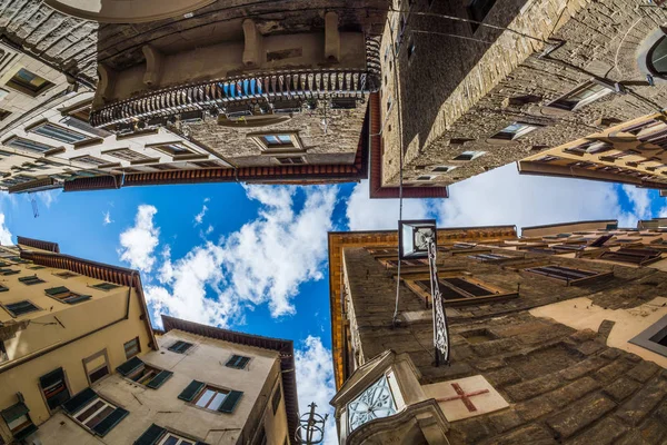 Una estrecha franja de cielo entre edificios antiguos atestados de gente — Foto de Stock