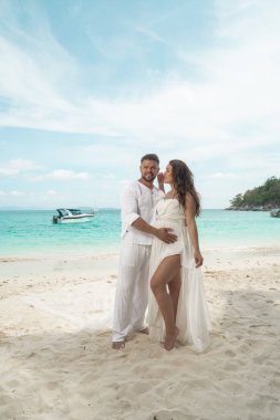 Çekici genç bir tropik adada kaç. Güzel kadın ve erkek birbirlerine kucaklayan ve trpoical tatil tatil kaçamağı zevk beyaz elbise giyen