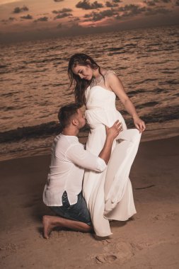 Güzel gün batımı sırasında tropikal kum plajındaki çekici romantik genç Çift