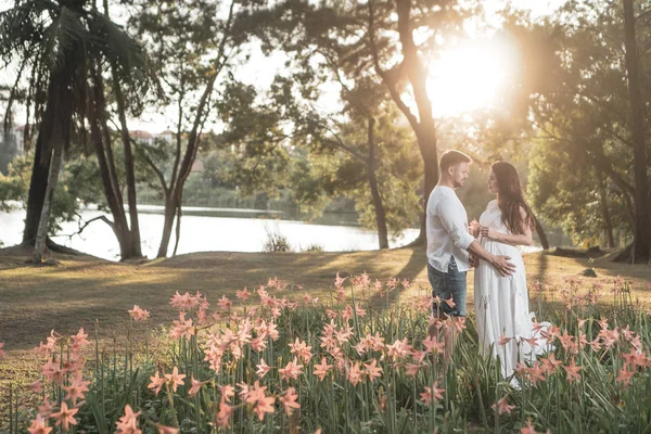 美丽的浪漫年轻夫妇在花园里的日落 — 图库照片