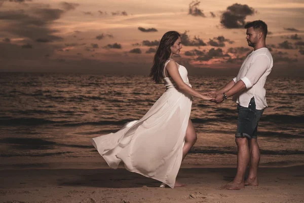 迷人的浪漫年轻夫妇在沙质热带海滩在美丽的日落 — 图库照片