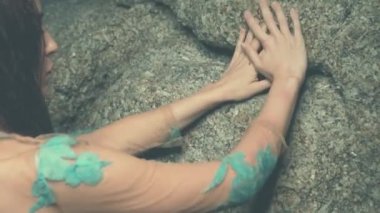 Sahilde günbatımı sırasında gizemli güzellik / eller gizemli kadının dokunaklı kayalar - slow motion video