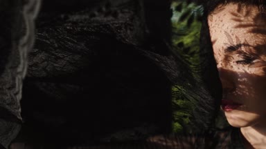 Güzel kadının dikey, dantel desen gölge ve güneş ışığı yüzünde / güzel dantel kumaş ile oynayan kadın. O pencerenin yakın duran ve dantel desen gölge ve güneş ışınlarının yüzünde - ağır çekimde video var