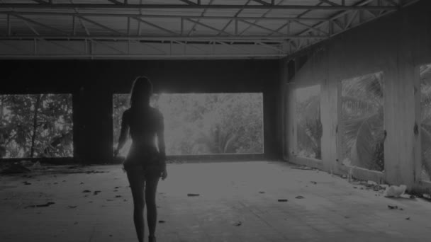 美しい女性に放棄された建物 ダウンで歩いている美しい女性の背面ビュー放棄スローモーションで建物 白と黒のビデオ — ストック動画