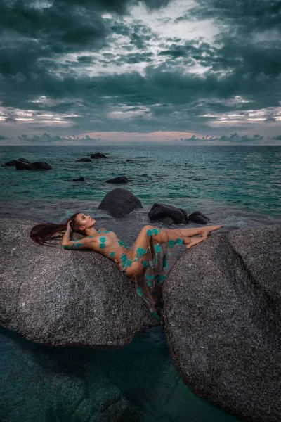 Beautiful Mysterious Woman Long Dress Laying Rocks Sea Cloudy Sunset — Stock Photo, Image