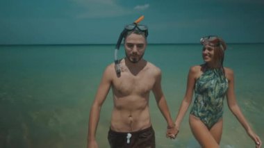Güzel çift sırasında yaz tatil/genç mutlu çift ağır çekim video - plaj tropikal tatil yaz günü güneşli zevk deniz suda eğlenmek şnorkel maskeleri ile