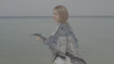 Mutlu gülümseyen kadın gülümseyerek ve kumaş eşarp ile tropik sahilde deniz ve gökyüzü arka plan üzerinde güneşli yaz gün boyunca oynamak plaj/mutlu güzel kadın