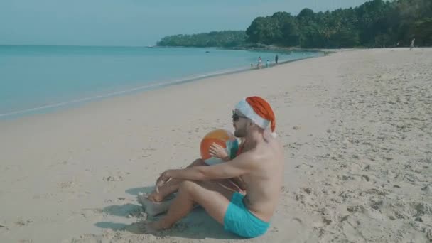圣诞节美丽的海滩情侣 圣诞节美丽的海滩情侣戴着圣诞老人的帽子在夏天的阳光下假日热带旅游目的地在寒假期间的爱情 — 图库视频影像