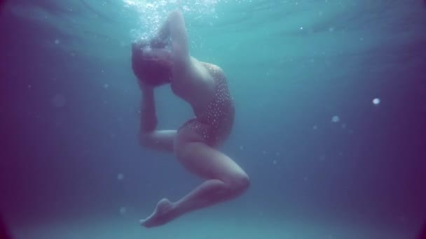 漂亮的女孩在水下 漂亮的女人穿着闪亮的泳衣在水下摆出姿势 慢镜头 — 图库视频影像