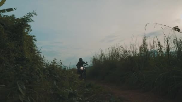 自由摩托车车手 凉爽的旅行者驾驶他的菜刀摩托车在热带岛屿公路与美丽的山景在多云清晨 视频慢动作 — 图库视频影像