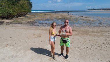 Deniz ve gökyüzü arka plan üzerinde drone ile mutlu gülümseyen çift ayakta tropik ada kumlu plajda tarafından çekilmiş fotoğrafı