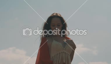 Güzel kadın pirinç tarlaları / güzel pirinç alanında bulutlu gökyüzü arka plan - ağır çekimde video üzerinde yürüme kırmızı şeffaf elbiseli Genç kadın