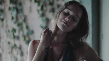 Güzel kadını binayı terk / Bina içinde ayakta creepers içinde ile duvarın üzerinden gülümseyen güzel kadın mutlu portre portre terk