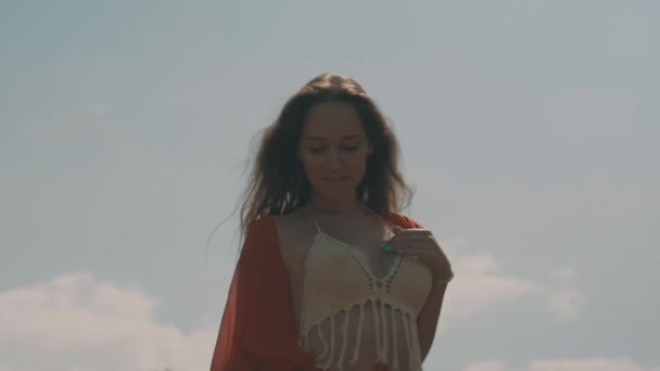 美丽的妇女在稻田里 美丽的年轻女子穿着红色透明的衣服走在稻田上空多云的天空背景 视频慢动作 — 图库视频影像