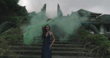 Güzel bir kadınla terk edilmiş otelin duman renkli / güzel kadınla terk edilmiş bir otel - ağır çekimde video açık havada giriş merdiven üzerinde duman renkli