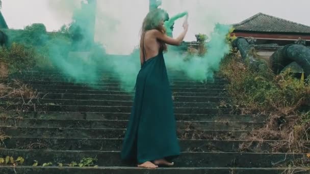放棄されたホテルで色と美しい女性の煙 を持つ美しい女性色の放棄されたホテル スローモーションでビデオの屋外エントランス階段上の煙 — ストック動画