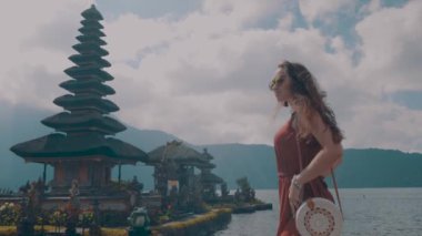 Genç kadın turist üzerinde Adası Bali, Endonezya - video ağır çekimde Ulun Danu Batur tapınağında onu tatil sahiptir