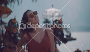 Portre portre genç kadın turist üzerinde Adası Bali, Endonezya - video ağır çekimde Ulun Danu Batur tapınağında onu tatil sahiptir