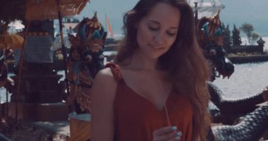 Tütsü tutarak ve Adası Bali, Endonezya - video yavaş hareket üzerinde Ulun Danu Batur Tapınağı'nda onun tatil keyfini genç kadın turist closeup portresi