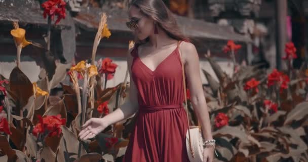 若い女性観光客がスローモーションでビデオ インドネシア バリ島でウルン バトゥールの美しい庭園寺院で彼女の休日を楽しんでいます — ストック動画