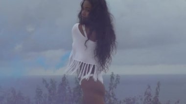 Renkli duman dağ sahasında okyanus ve bulutlu gökyüzü arka plan - ağır çekimde video oynatma ile güzel kız portresi