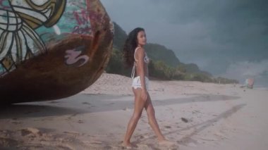 Güzel kız şaşırtıcı günbatımı - video yavaş hareket sırasında yakınındaki batık kumlu plajda yürüyüş