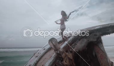 Hava dron görünümü güzel kızla sahilde batık duman ayakta şaşırtıcı günbatımı - ağır çekimde video sırasında renkli