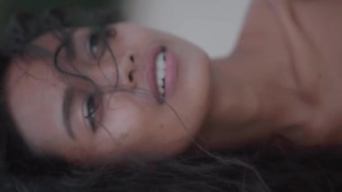 Güzel kız dururken kumlu plajda - ağır çekimde dikey video kamera bakarak closeup portresi