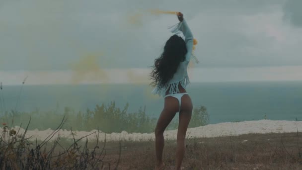 海と曇り空の背景 スローモーションでビデオ山フィールドで対戦色付きの煙で美しい少女 — ストック動画