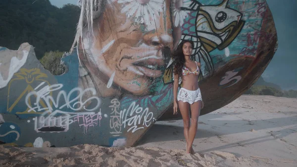美丽的女孩比基尼站在沙滩上的废弃沉船 — 图库照片