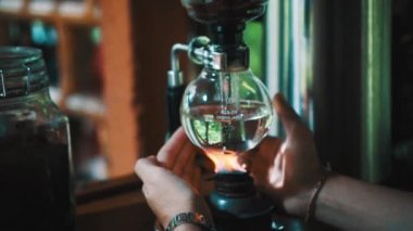 Ateş Luwak kahve ile vakum altında kapsayan eller. Alternatif kahve makinesi Makinası - ağır çekimde video şaşırtıcı görünümü