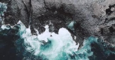 Okyanus dalgalar çökmesini kıyı şeridi cliff - video yavaş hareket hava dron görünümü