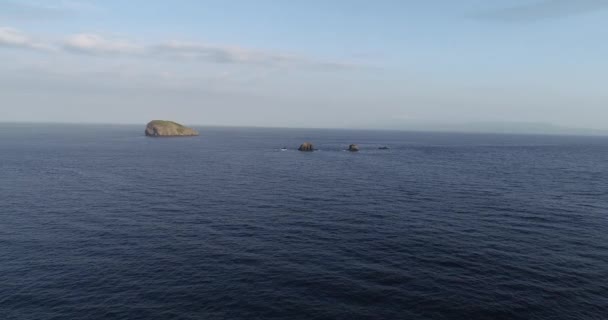 青い曇り空を背景に海の上の小さな島の空中ドローン ビュー — ストック動画