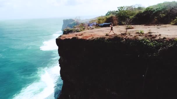 Légi Drone Csinos Lány Játszik Színes Füst Sziklán Csodálatos Óceán — Stock videók