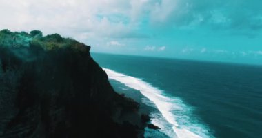 Güzel kızın muhteşem okyanus ve bulutlu gökyüzü görünümü - ağır çekimde video uçurumun altındaki renkli duman ile oynamak hava dron vurdu