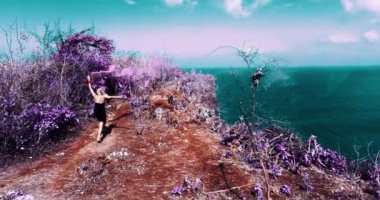 Güzel kızın muhteşem okyanus ve bulutlu gökyüzü görünümü - ağır çekimde video uçurumun altındaki renkli duman ile oynamak hava dron vurdu